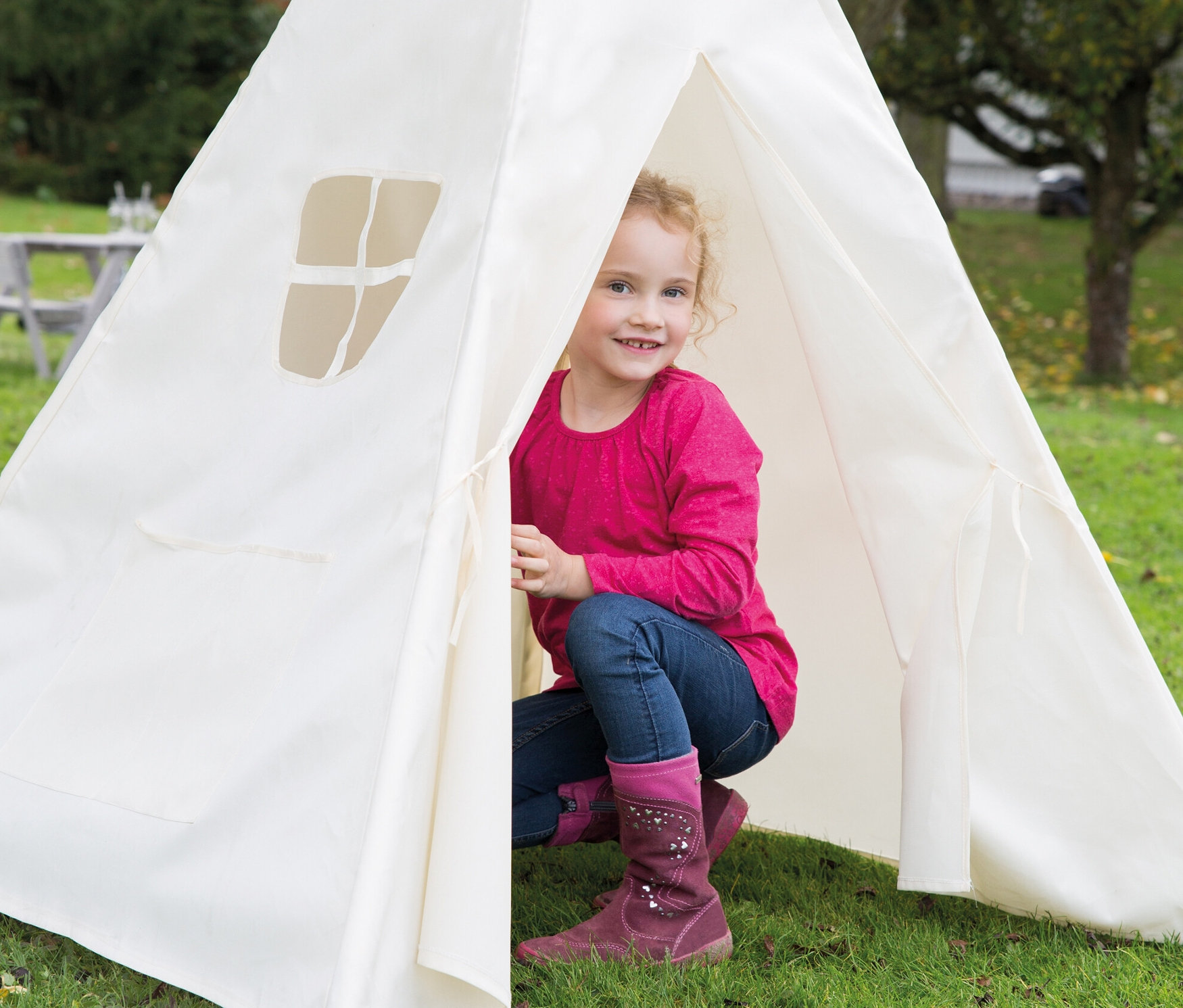Lächelndes Mädchen posiert im roba Kinderspielzelt Tipi.