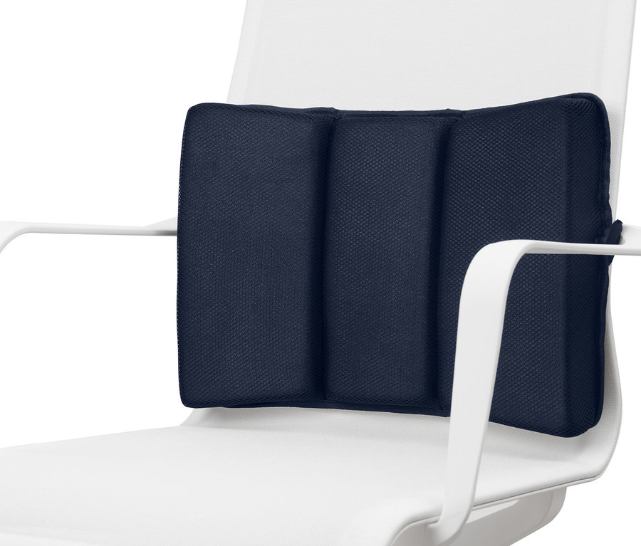 Ein marineblaues Memory-Foam-Lendenkissen auf einem weißen Stuhl.