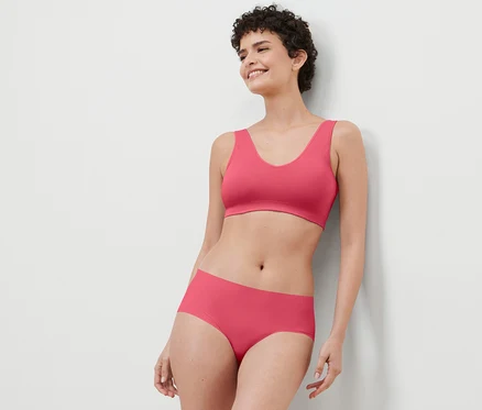 Frau posiert in korallenroten 2 Magic-Cut-Pantys.