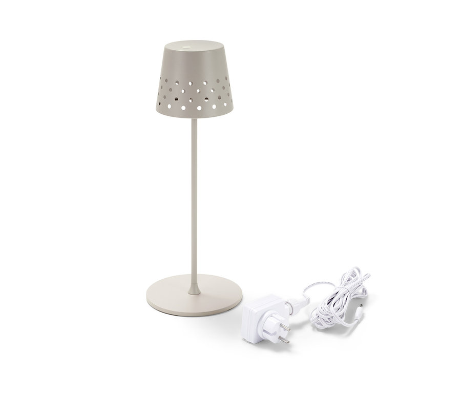 Eine beigefarbene LED-Akku-Tischleuchte aus Metall und ein Ladekabel auf einem weißen Hintergrund.