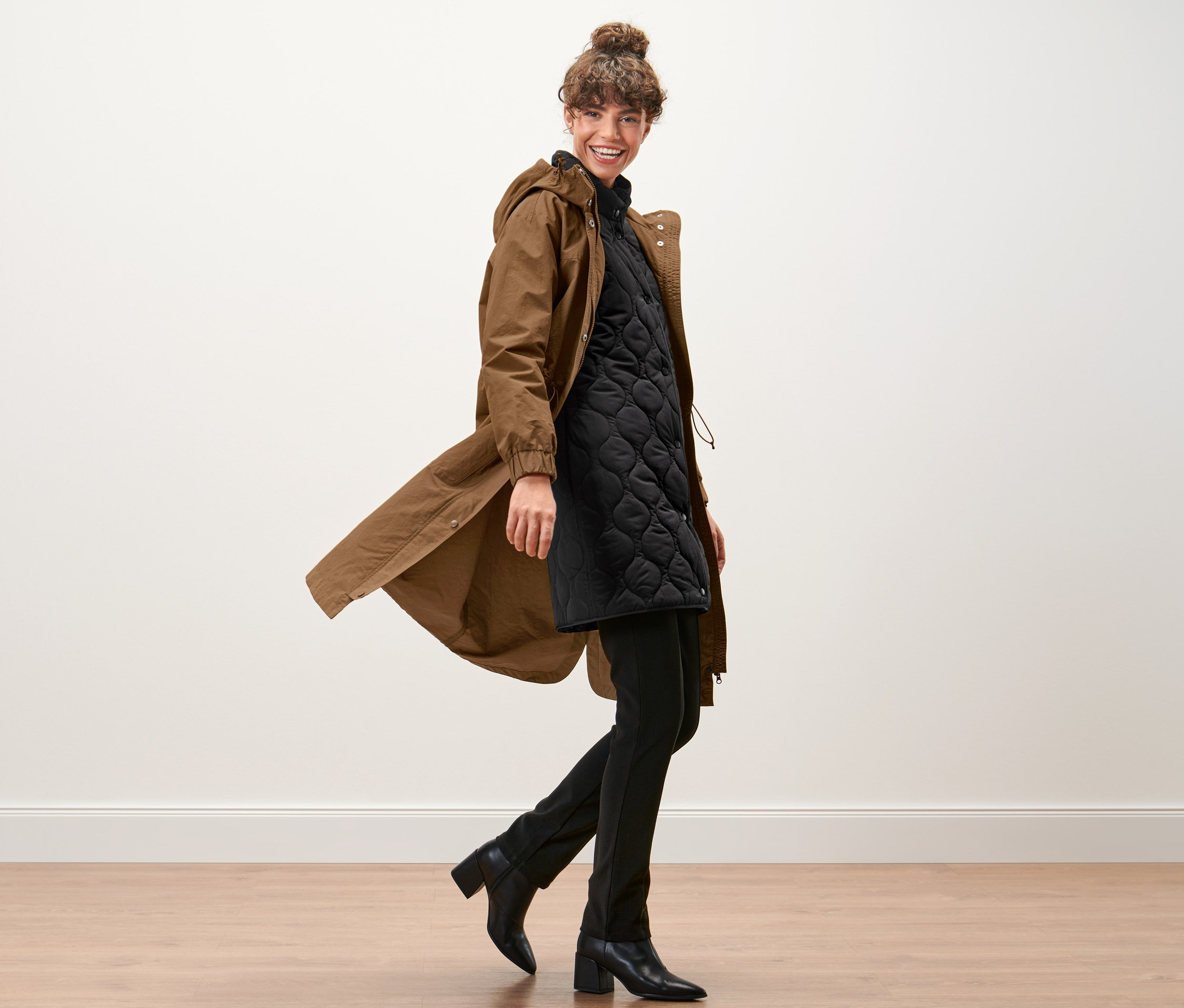 Frau geht und trägt eine Parka mit Weste.