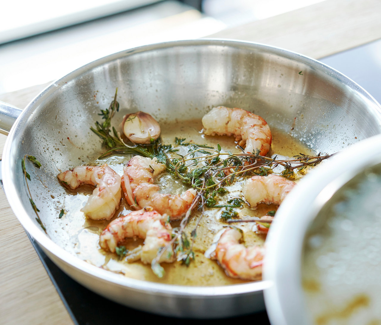 Gekochte Garnelen mit Knoblauch und Thymian in einer silbernen Zwilling PRO Edelstahl Pfanne (ca. 20 cm).