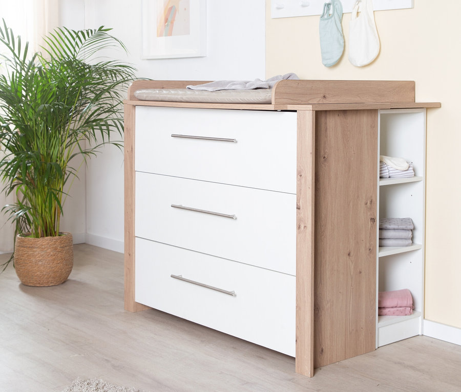 Eine weiße Wickelkommode »Malo« von roba mit drei Schubladen steht in einem Kinderzimmer.