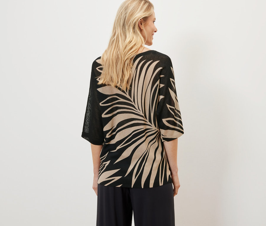 Frau trägt bedruckten Feinstrickpullover.