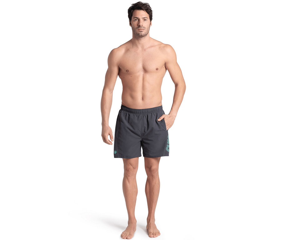 Mann posiert in grauen Badeshorts.