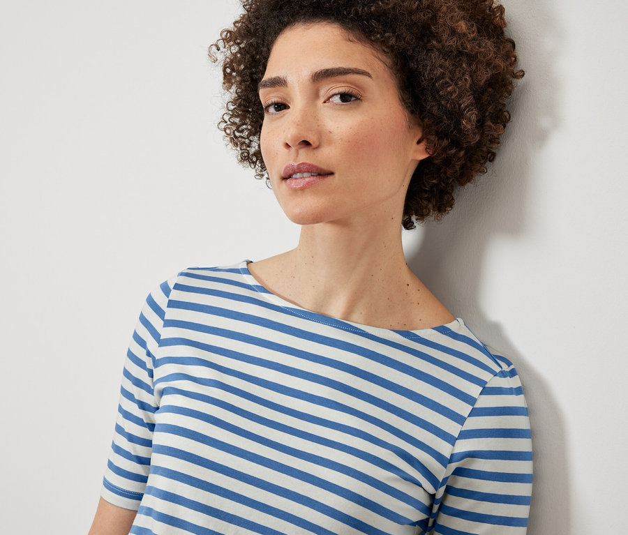 Frau trägt blau gestreiftes Halbarmshirt.