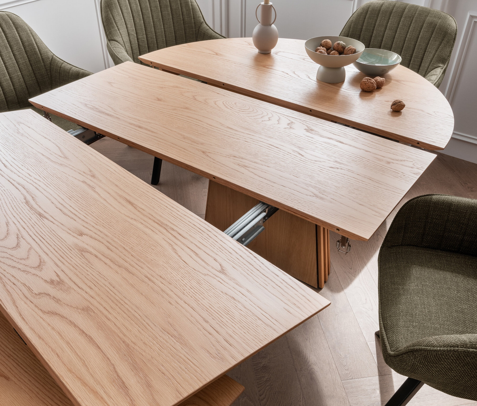 Teilweise ausgezogener ovaler Esstisch deVries Diningtisch »Oria«, Natur Oak, 120/210 x 120 cm, mit vier grünen Stühlen.