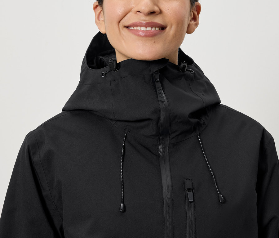 Lächelnde Frau trägt eine schwarze Kapuzenjacke.