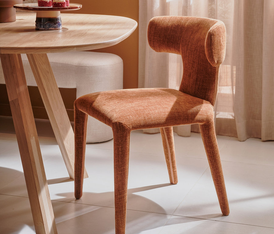 Ein zimtfarbener BePureHome Stuhl »Permit« aus einem 2er-Set steht neben einem Holztisch.