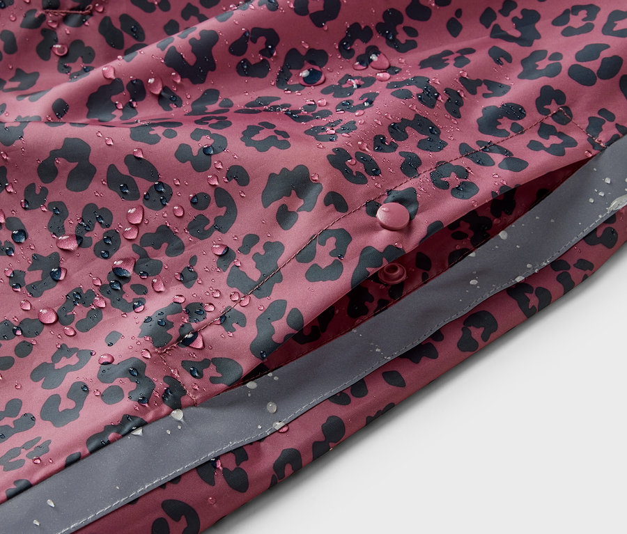 Detailansicht eines rosa Kinder-Regenponchos mit Alloverprint und Wassertropfen.