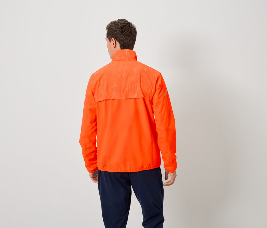 Mann von hinten trägt eine orangefarbene Jacke und dunkelblaue Hosen.