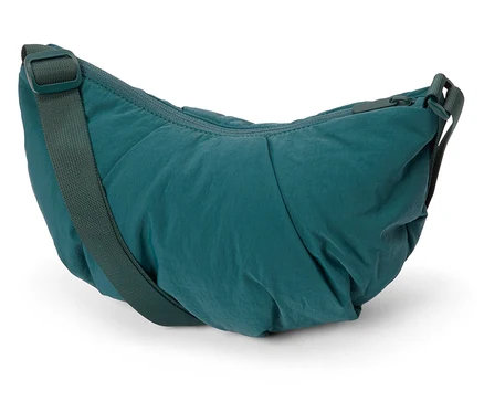 Nahaufnahme einer grünen Umhängetasche aus Nylon vor weißem Hintergrund.