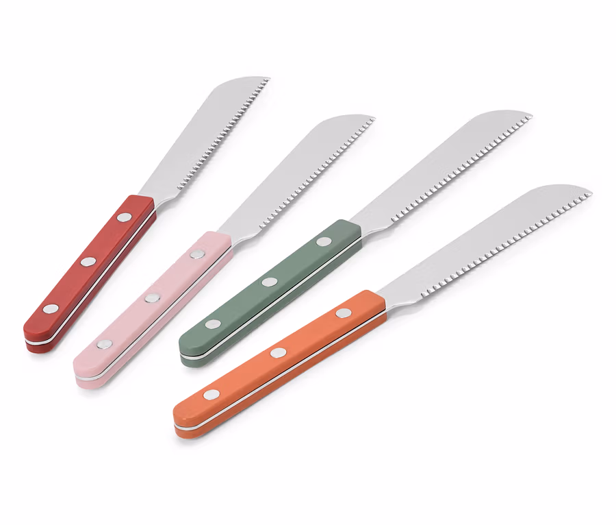 Vier Brotmesser mit roten, rosa, grünen und orangefarbenen Griffen liegen diagonal auf einem weißen Hintergrund.