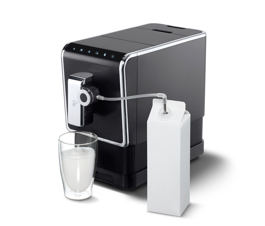 Anthrazitfarbener »Esperto Pro« Tchibo Kaffeevollautomat mit Milch im Glas und Karton.