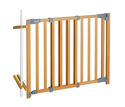 roba Treppenschutzgitter #187;Safety Up#187; aus hellem Holz mit vertikalen Sprossen und grauen Metallbeschl&auml;gen, an einem wei&szlig;en Pfosten befestigt.