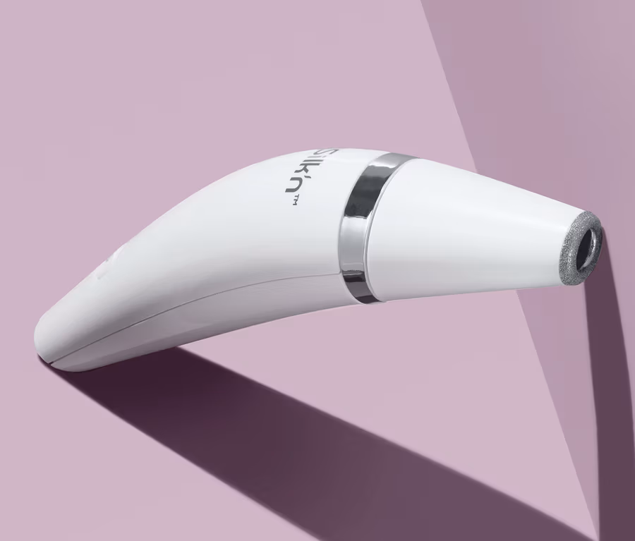 Nahaufnahme des weißen Silk’n®-ReVit-Essential-Mikrodermabrasionsgeräts auf lila Hintergrund.