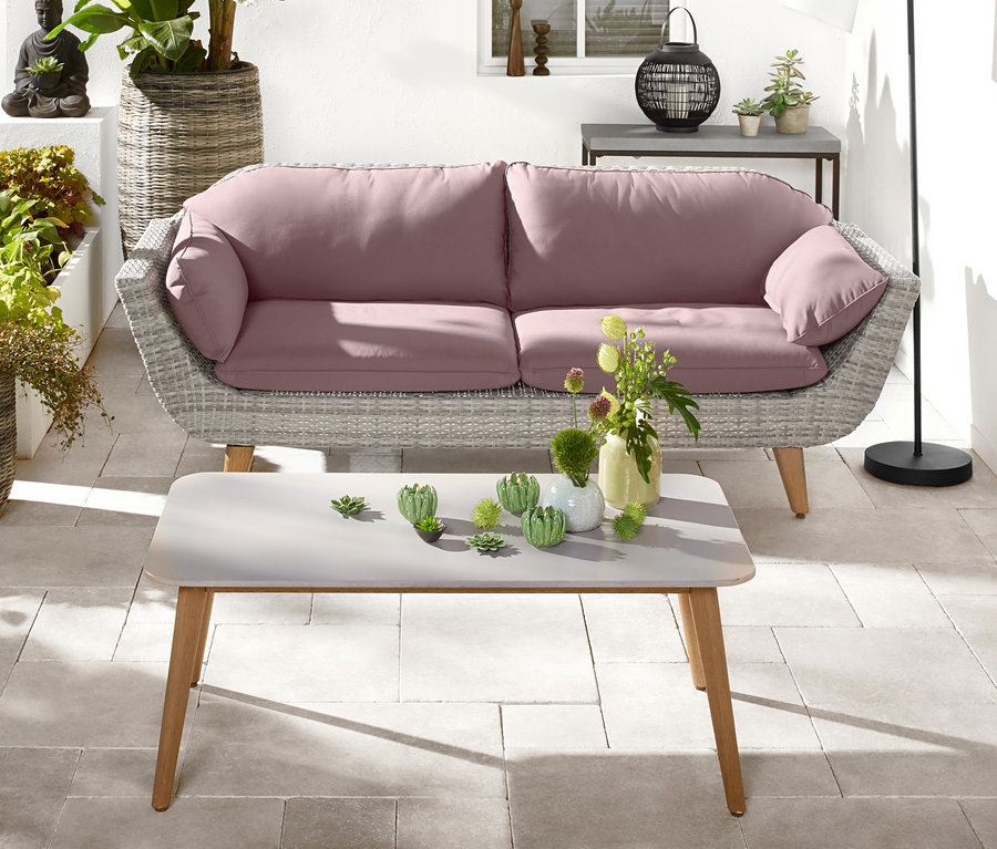 Eine Gartenterrasse mit einem Komfort-Gartensofa für 3 Personen, einem Couchtisch (60 x 110 cm), einer LED-Stehleuchte Downlight für den Außenbereich und einem Pflanzkübel aus Polyrattan (ca. 48 x 92 cm).