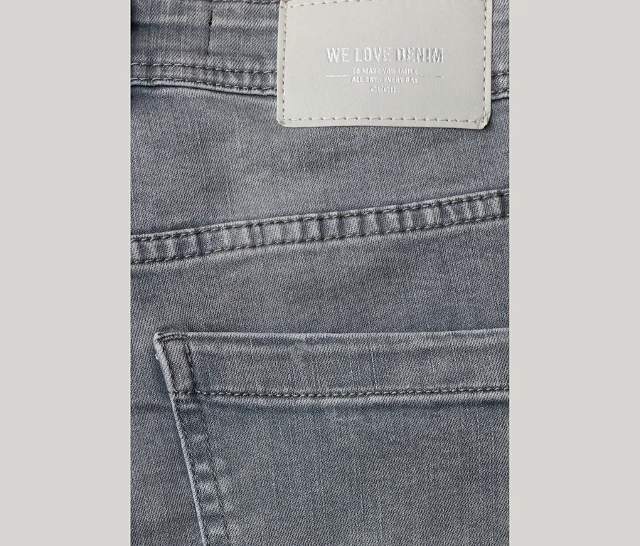 Graue CECIL Jeans mit sichtbaren Nähten, einer Gesäßtasche und einem hellgrauen Etikett mit der Aufschrift „WE LOVE DENIM“ und „CECIL“.