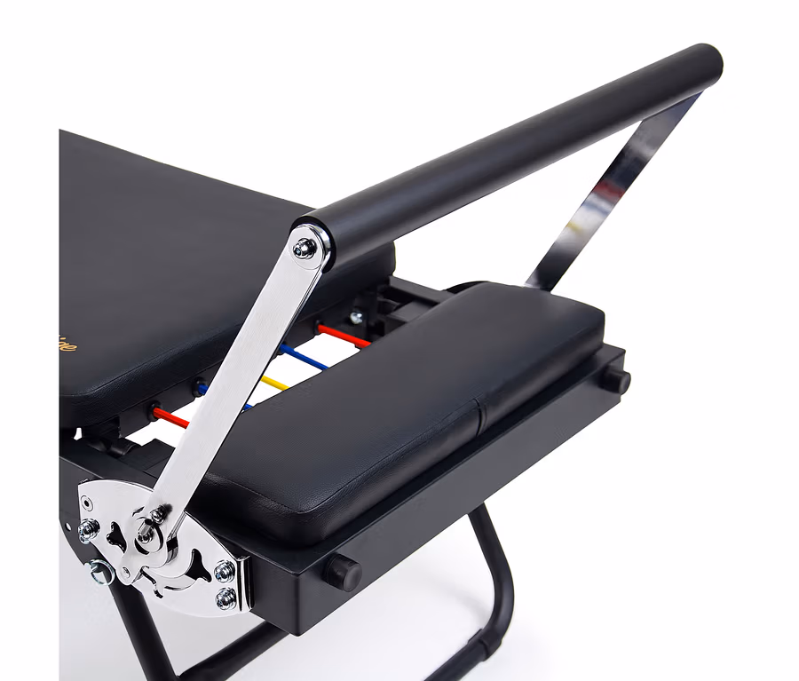 Christopeit Pilates Reformer 2000 in Schwarz mit gepolsterten Flächen, Chromarm und farbigen Widerstandsbändern.
