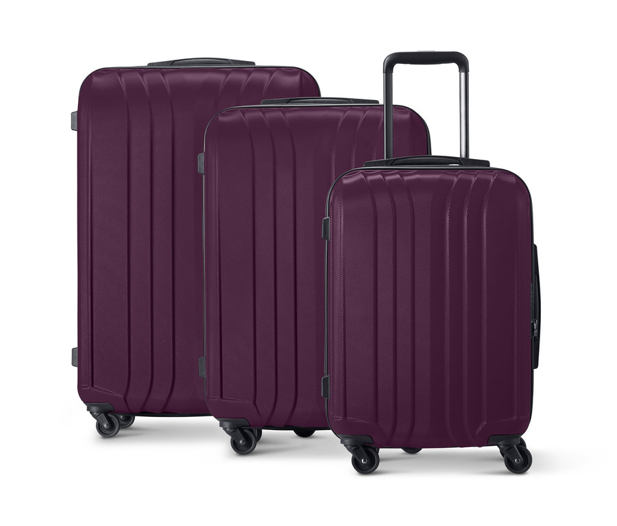 Drei violette Hartschalen-Koffer unterschiedlicher Größe stehen nebeneinander.