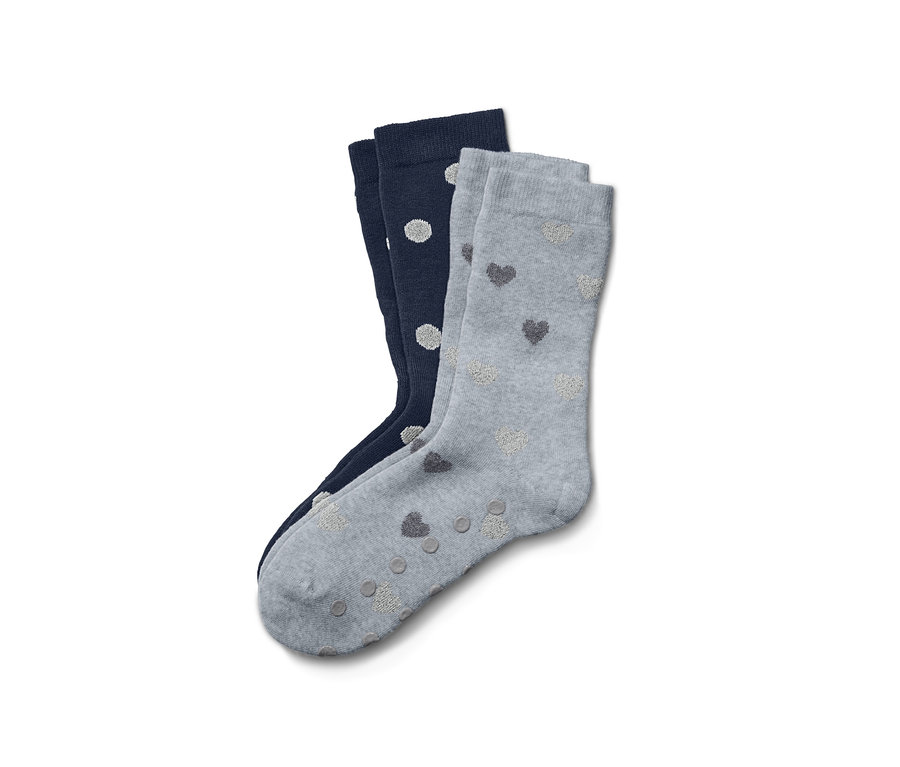 Zwei Paar Antirutschsocken: ein Paar marineblau mit weißen Punkten und ein Paar grau mit Herzen.