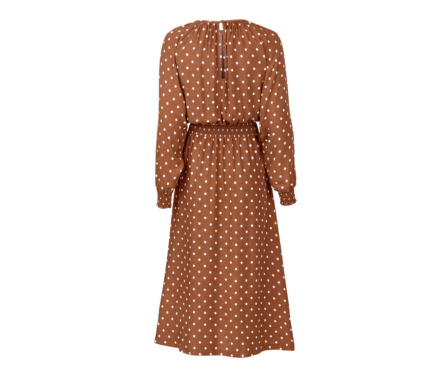 Detailansicht eines gepunkteten Midi-Kleids mit langen Ärmeln und braunem Hintergrund.