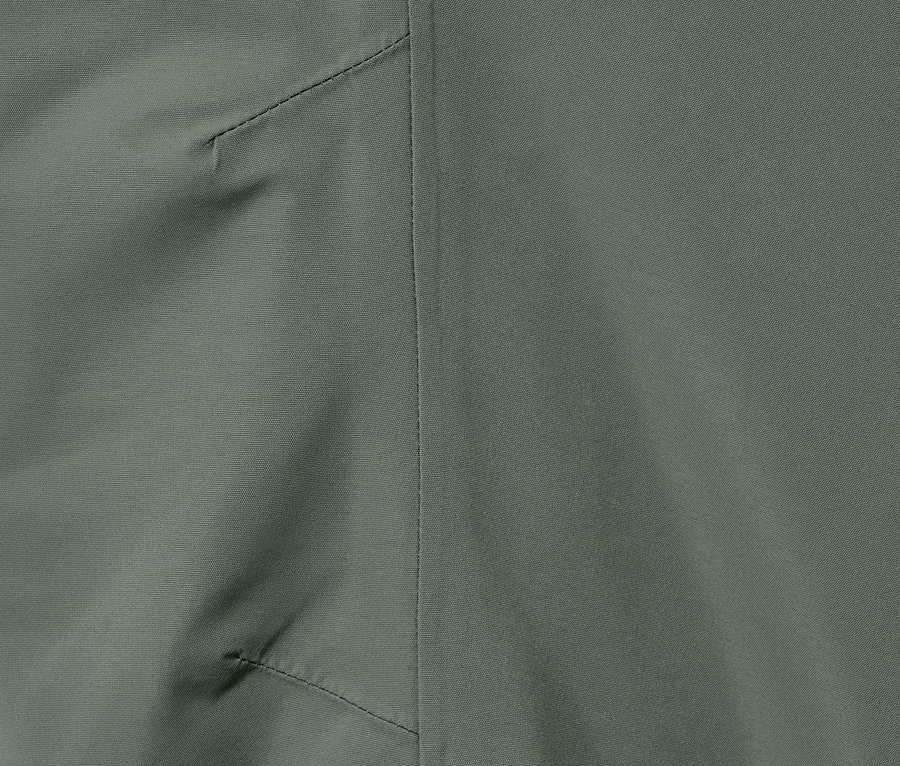 Detailaufnahme einer grünen Regenhose mit reflektierendem Streifen.