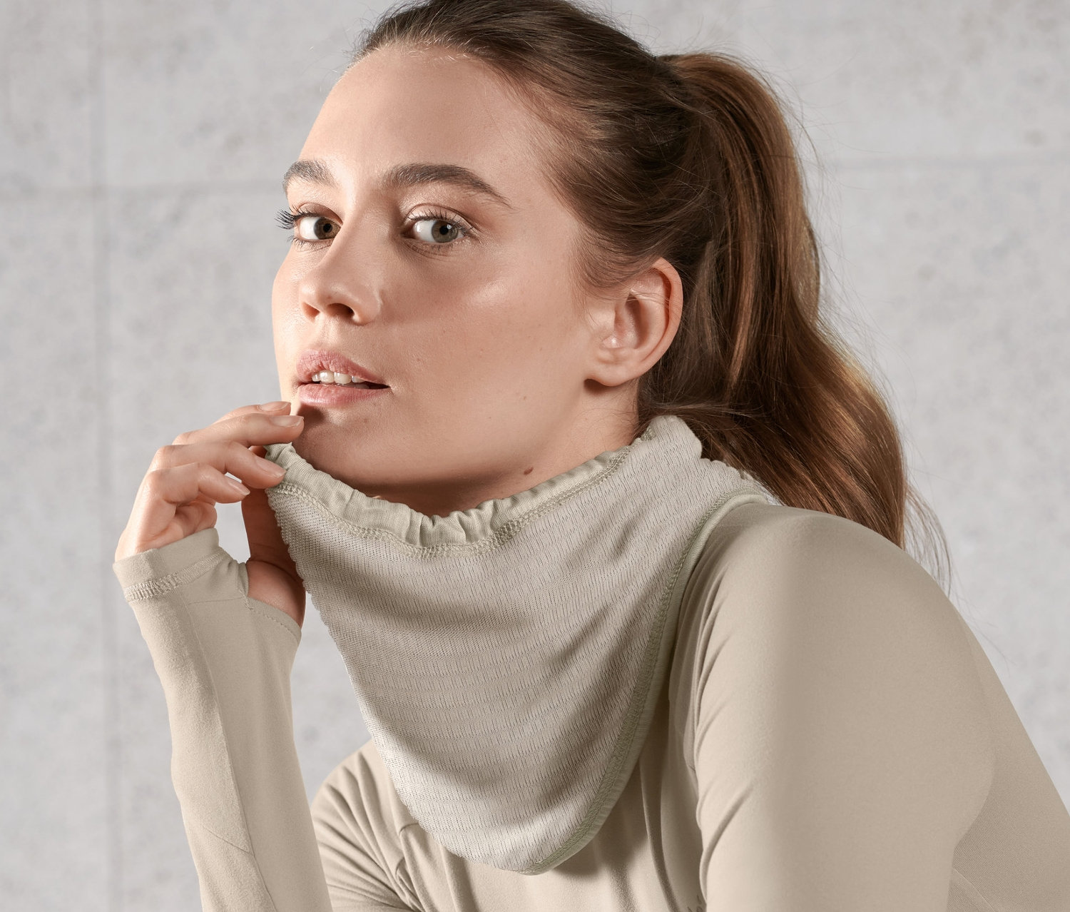 Frau trägt hellbraunes Thermo-Multifunktionstuch und Langarmshirt.