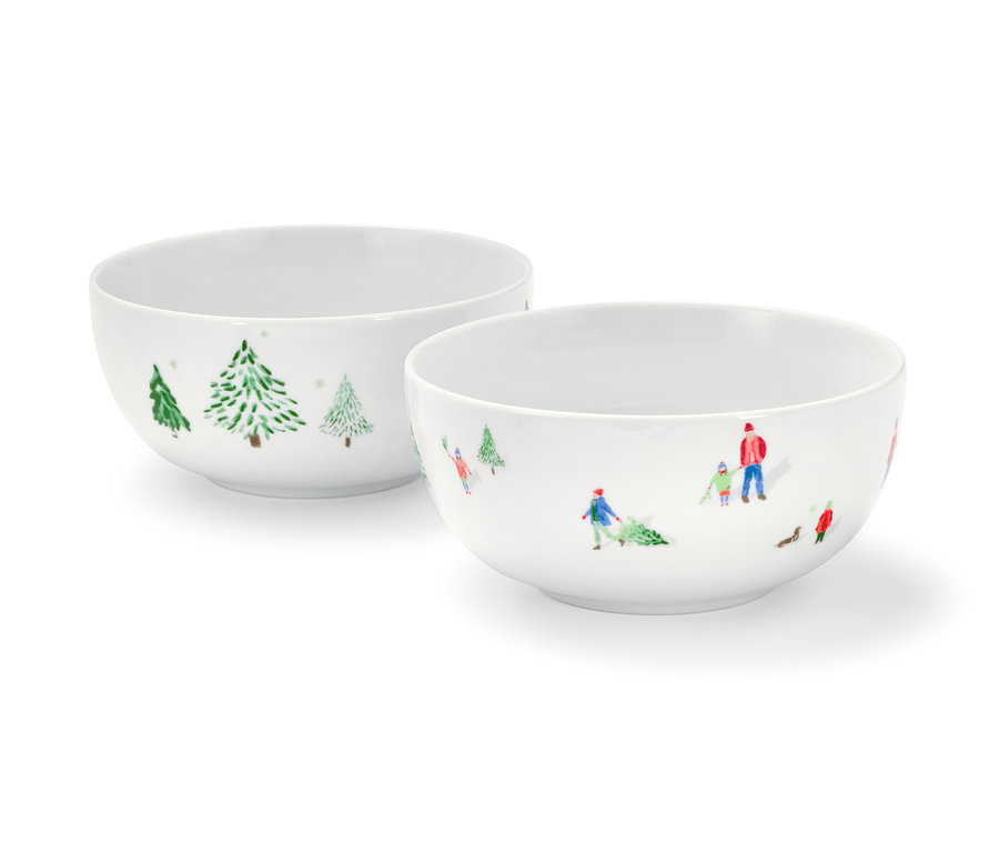 Zwei Müslischalen mit Winterlandschaftsmotiv und Menschen, die Weihnachtsbäume ziehen.