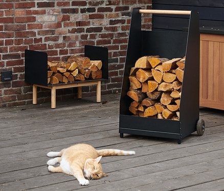Auf der Terrasse liegt eine rote Katze neben einem Kaminholz-Wagen. Im Hintergrund sind ein Kaminholz-Regal, eine LED-Filament-Laterne und eine LED-Outdoor-Lichterkette zu sehen.