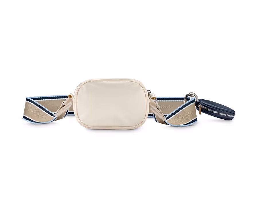 Eine cremefarbene Crossbody-Tasche mit einem gestreiften Gurt und einer kleinen, dunkelblauen Tasche.
