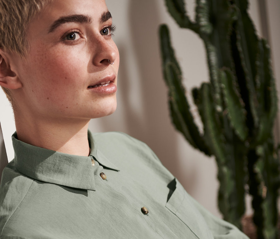 Frau mit kurzen Haaren in Hemdbluse.