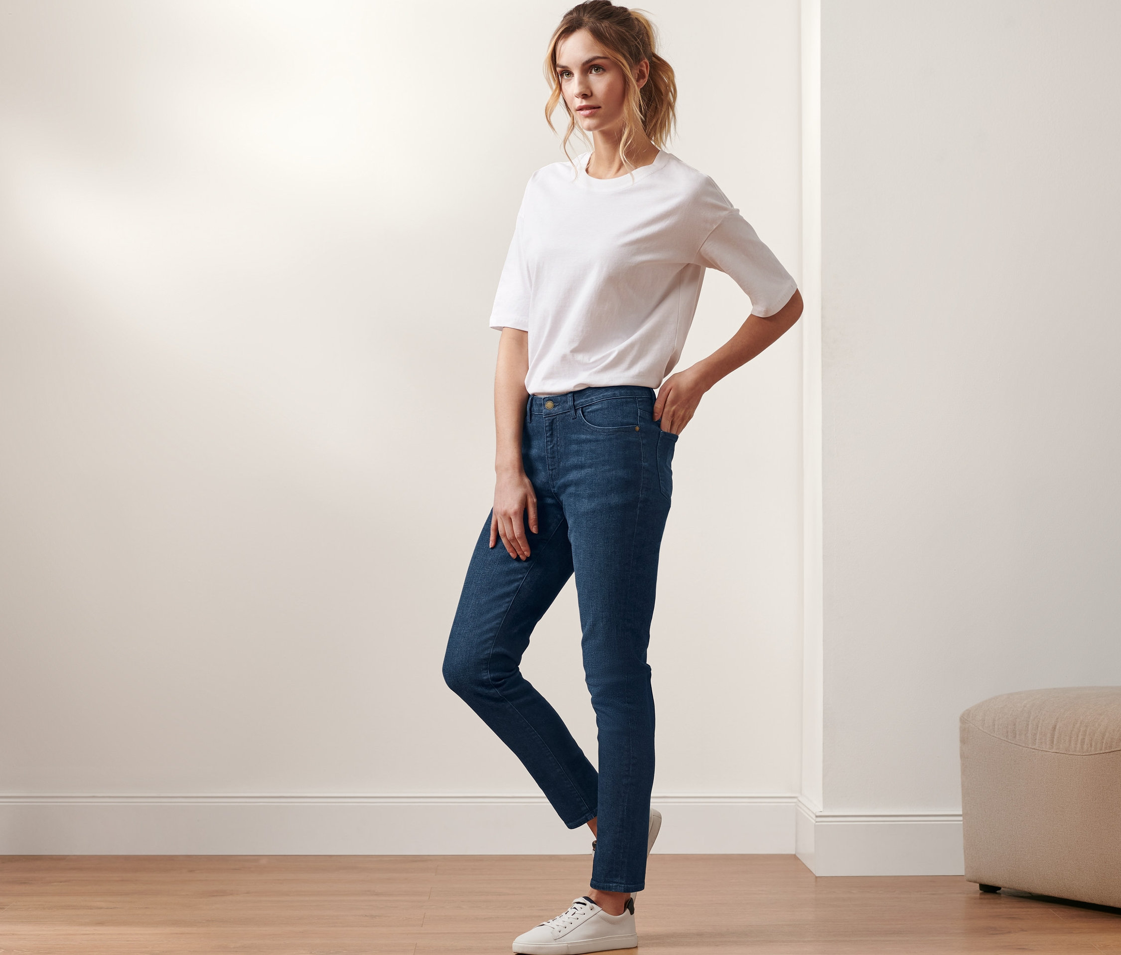 Frau posiert in Slim-Denim »Fit Emma«, dark blue denim und weißem T-Shirt.