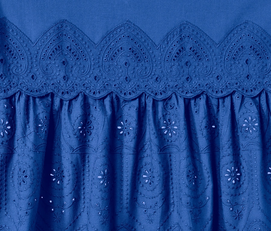 Detail einer blauen Longbluse mit Stickerei.