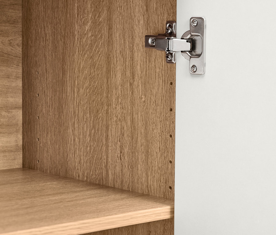 Detailansicht vom Inneren eines Bekeson Schranks mit einer weißen Tür und Holzböden.