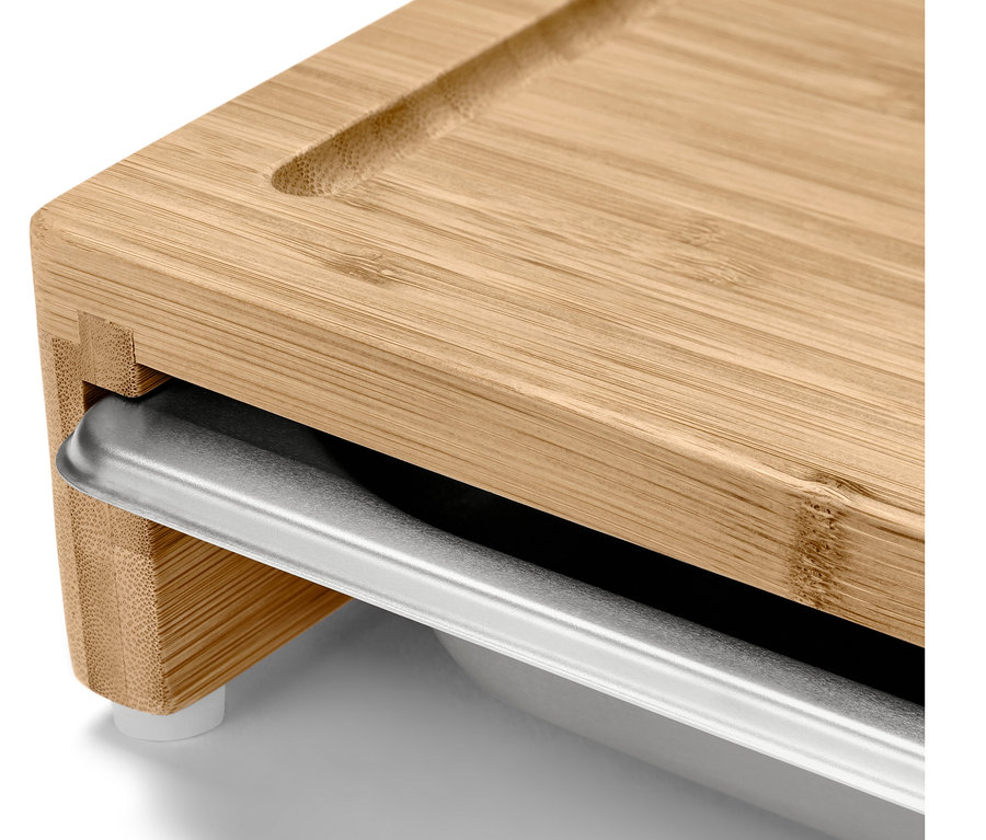 Detailaufnahme eines Schneidebretts mit einer Metallschublade.