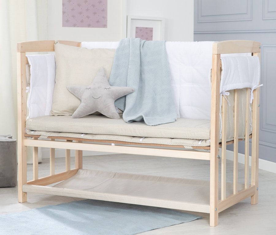 Gitterbett mit Sternkissen, Decke und Bettwäsche.