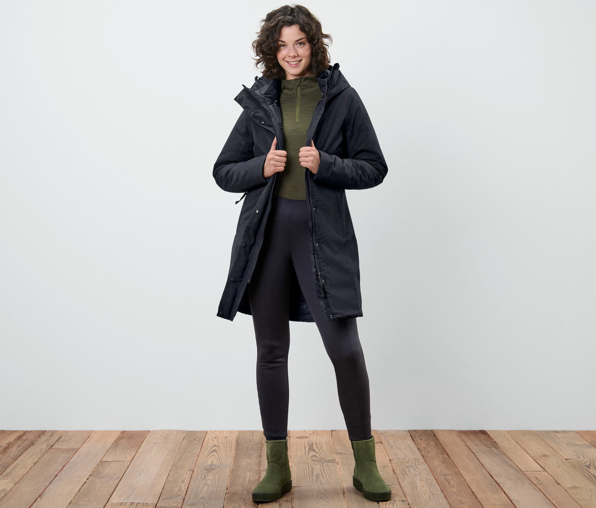 Frau posiert in dunkelblauem Thermo-Mantel.