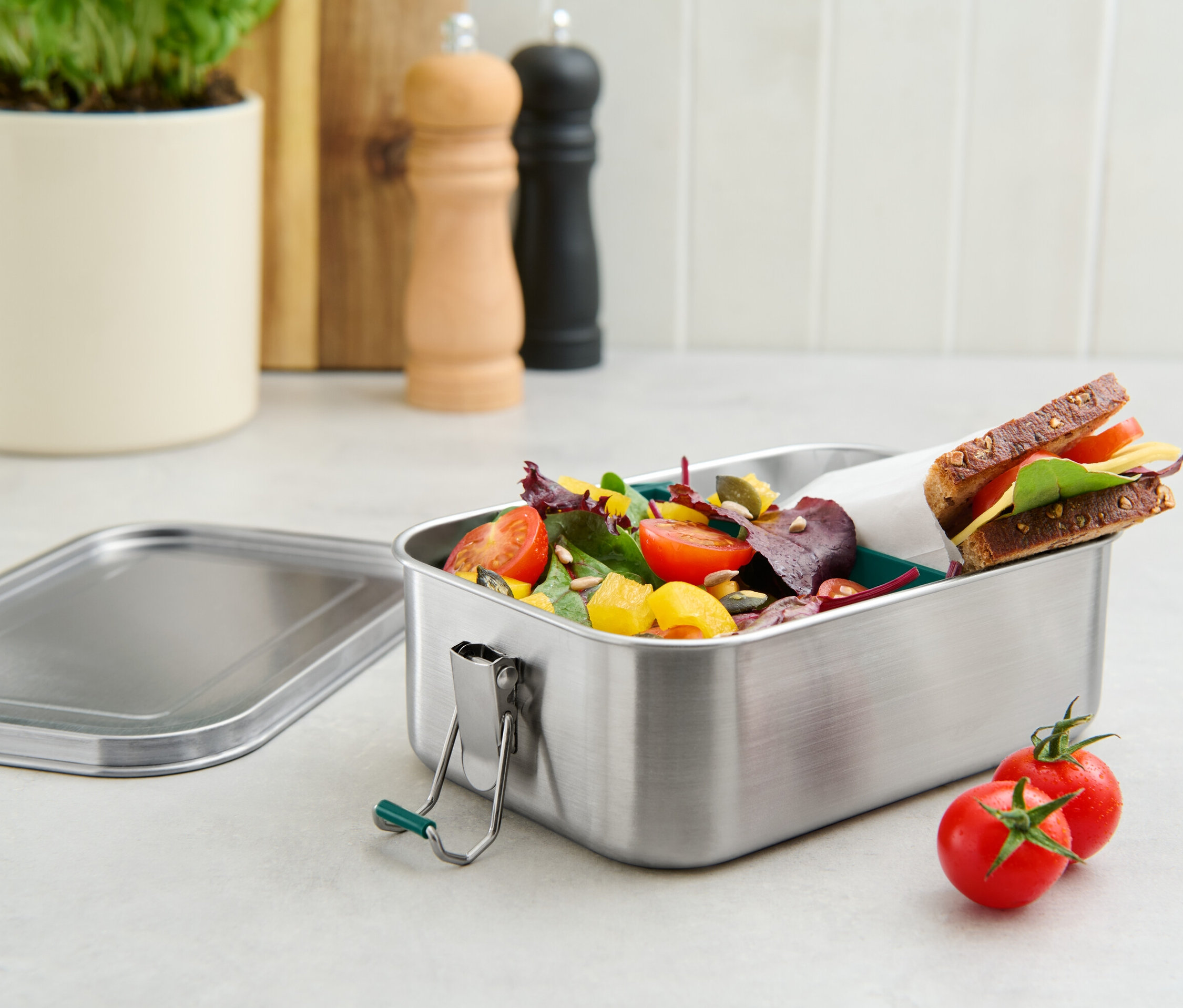 Eine To-go-Lunchbox aus Edelstahl gefüllt mit Salat und einem Sandwich.