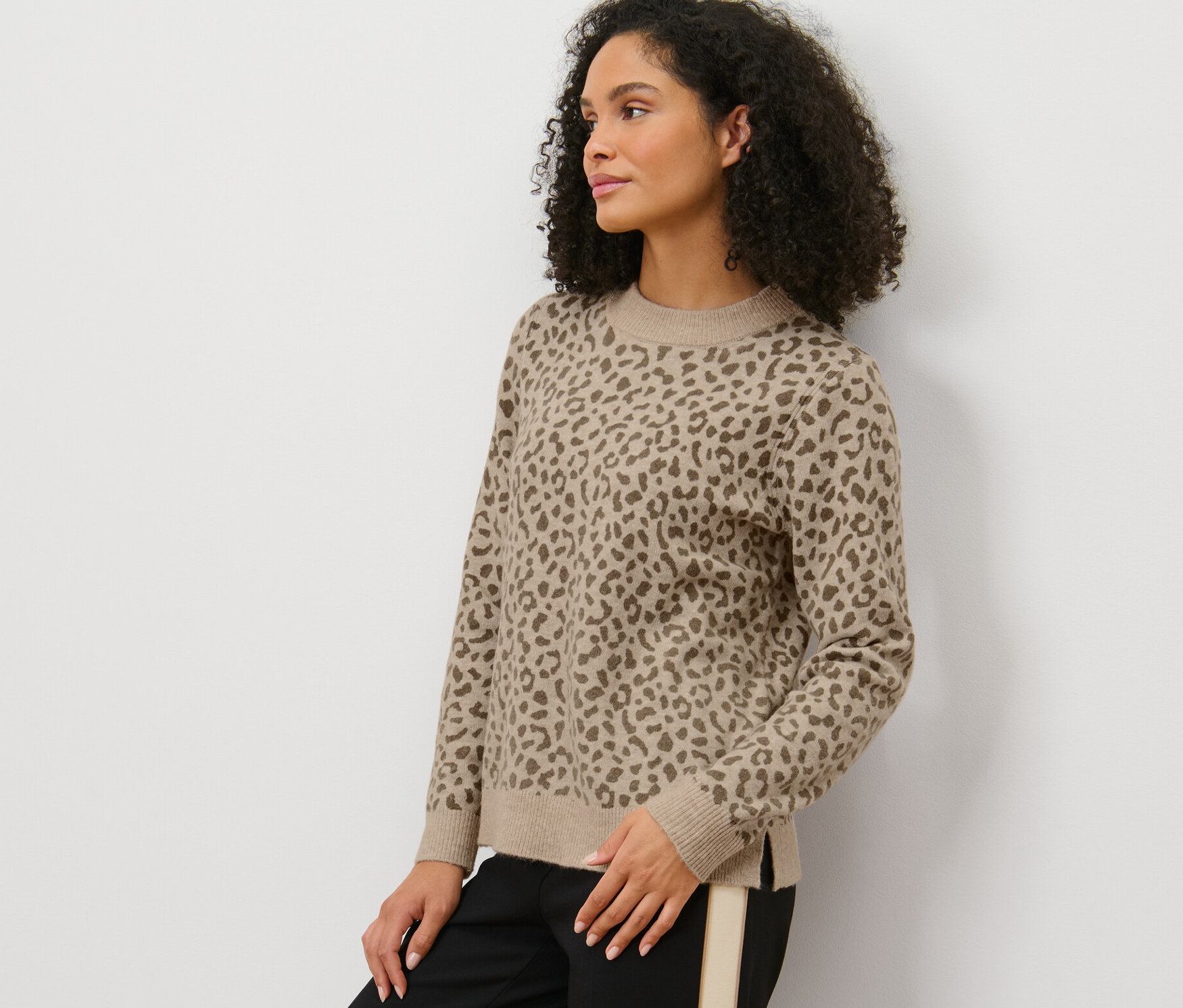 Frau posiert in bedrucktem Strickpullover.