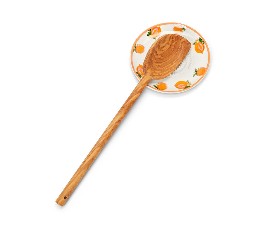 Eine Tellerreibe mit einem Holzlöffel.