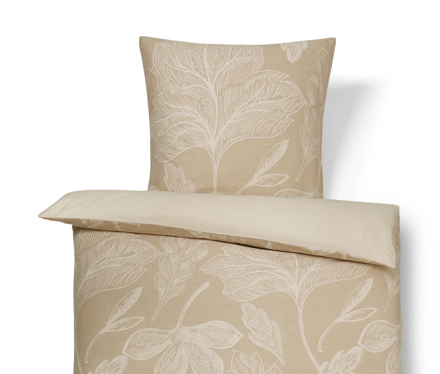 Beige Bettwäsche mit Blattmuster.