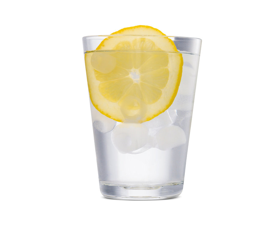 Ein Glas Wasser mit einer Zitronenscheibe und Eiswürfeln.