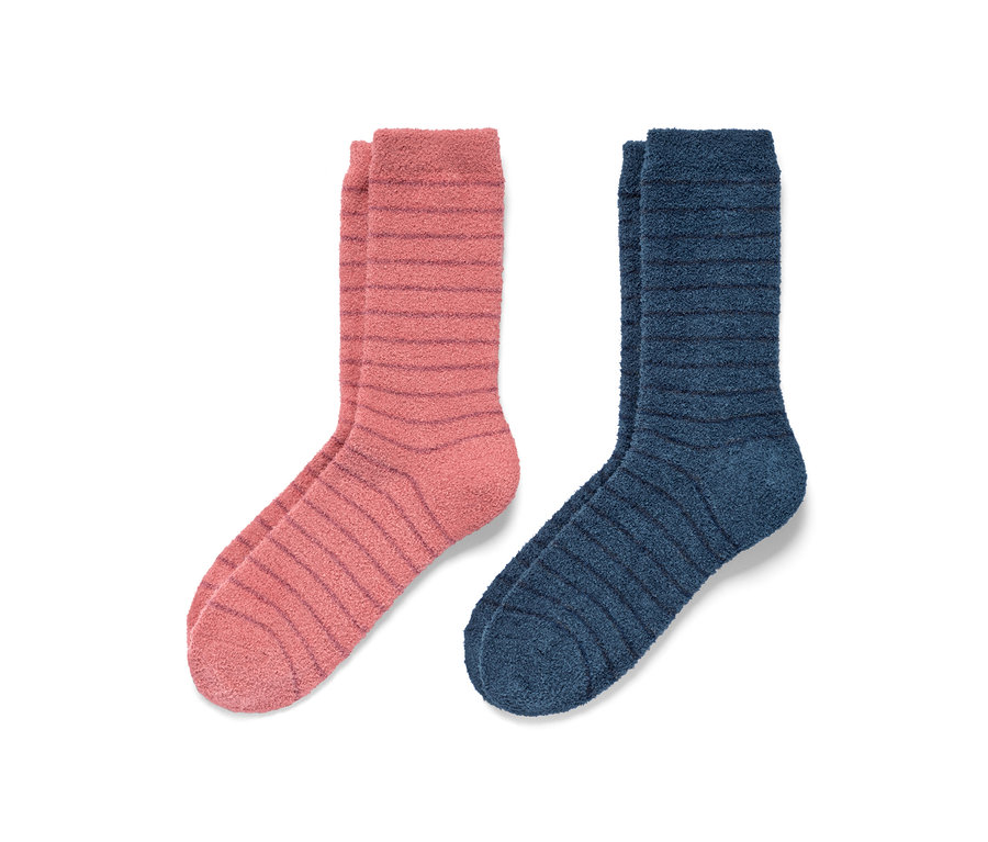 Zwei Paar flauschige Kuschelsocken: ein Paar rosa gestreift, ein Paar blau gestreift.