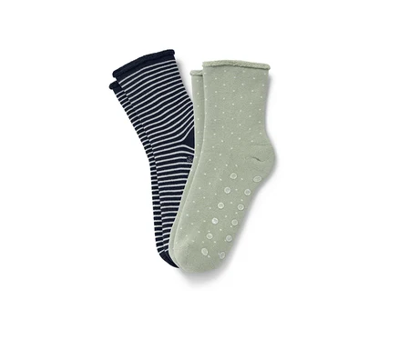 Zwei Paar Hygge-Socken: ein Paar ist dunkelblau mit weißen Streifen, das andere hellgrün mit weißen Punkten.