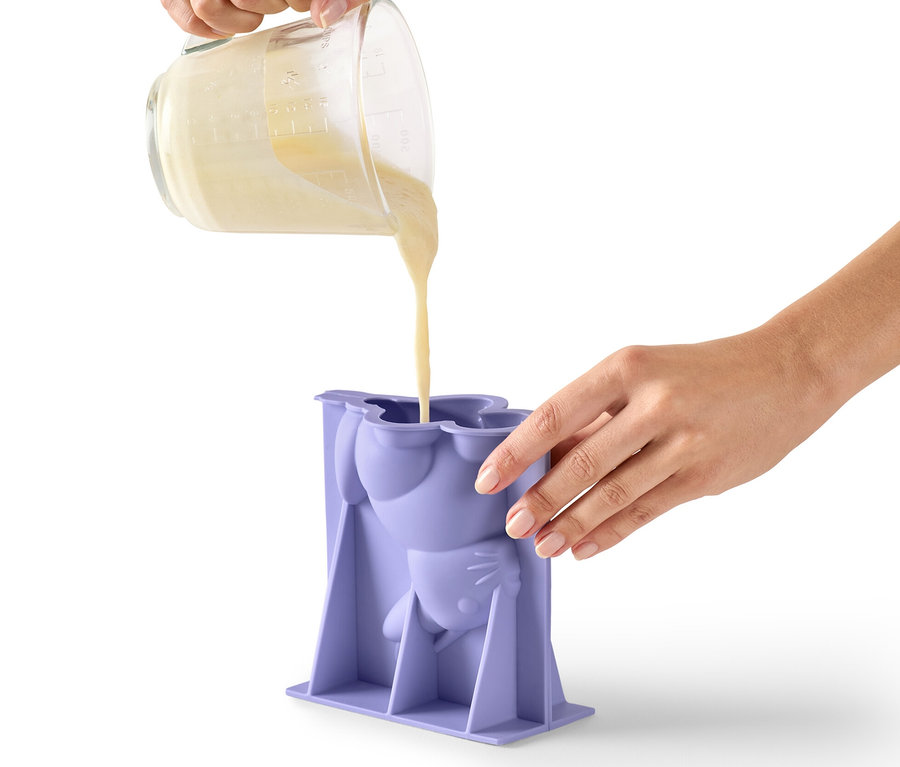 Person gießt Teig in eine lila Osterhasen-Backform.