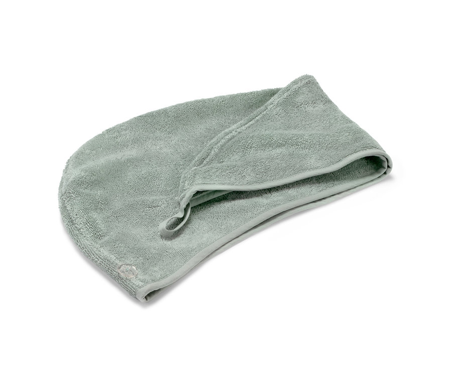 Ein hellgrünes Turban-Handtuch liegt auf einem weißen Hintergrund.