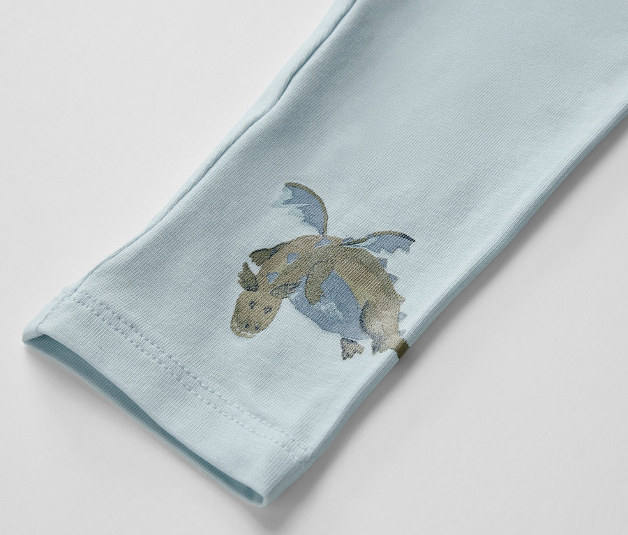 Detailaufnahme einer hellblauen Kinderleggings mit Drachenprint.