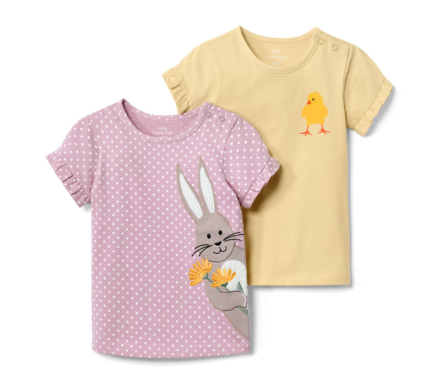 Zwei Kleinkinder-T-Shirts: ein rosafarbenes mit weißen Punkten und Hasenapplikation, ein gelbes mit Küken.