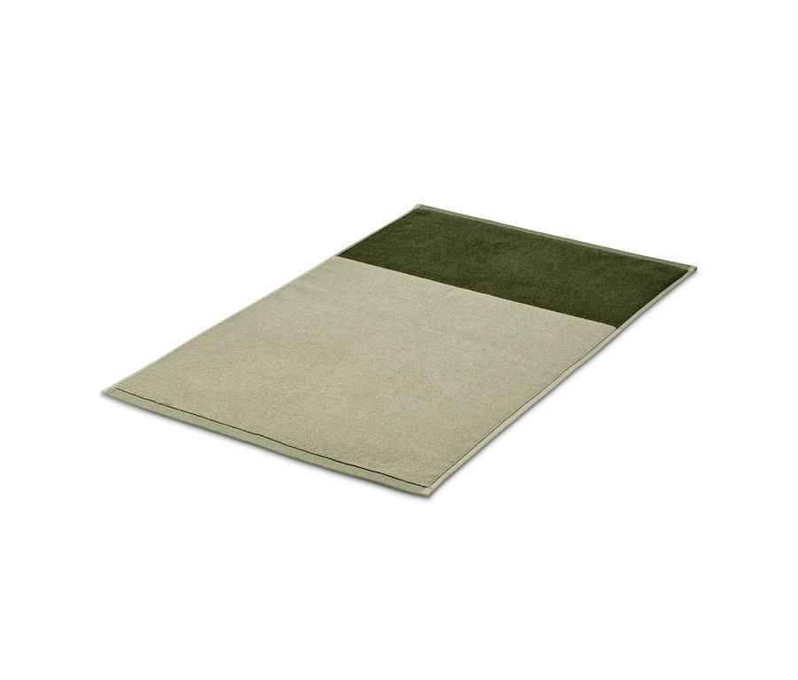 Hochwertiger Jacquard-Duschvorleger, sandgrün-moosgrün, liegt auf einem weißen Hintergrund.